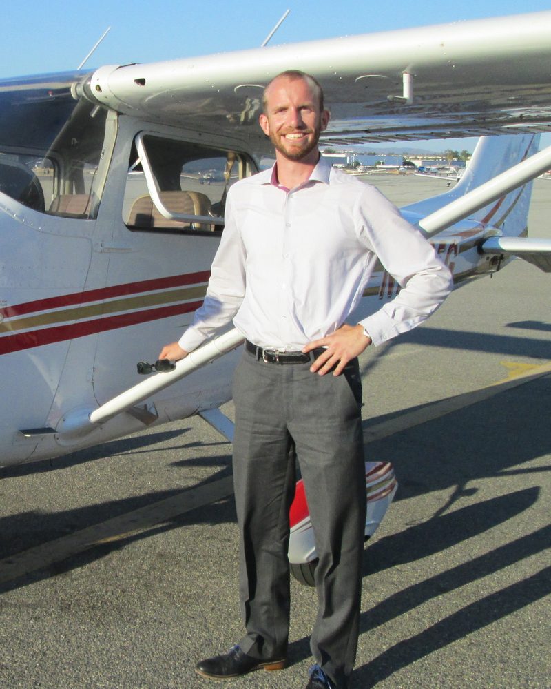 Alex Hedbany beside a Cessna training airplane on the ramp